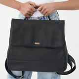 Model holding Black Bare Leather Lottie Backpack. Front