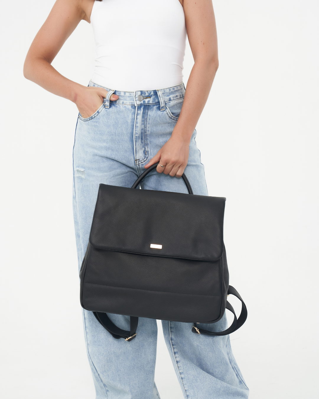 Model holding the Black Bare Leather Lottie Backpack in front of her. Front