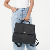 Model holding the Black Bare Leather Lottie Backpack in front of her. Front