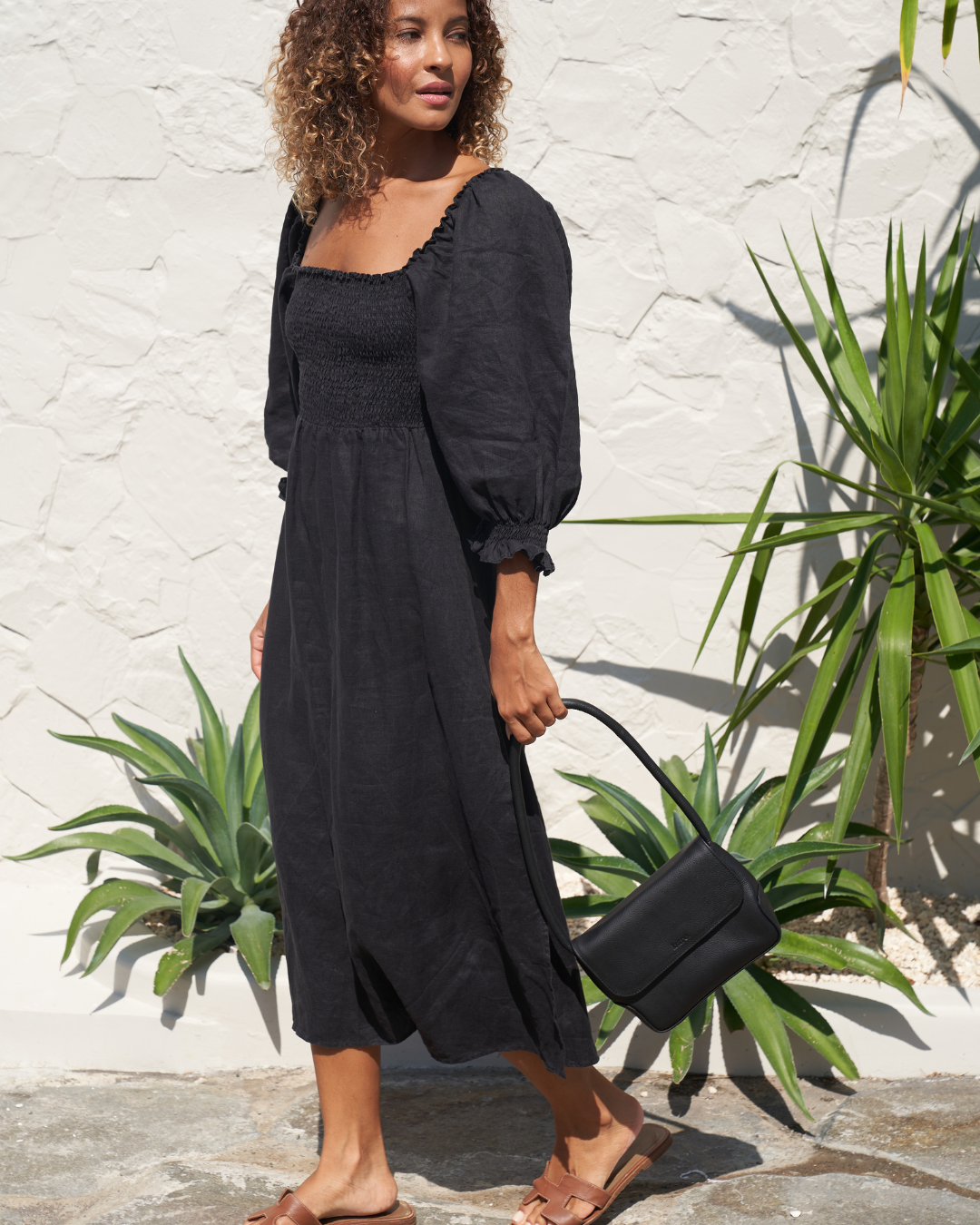 Model holding Black Bare Leather Patsy bag. Front