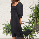 Model holding Black Bare Leather Patsy bag. Front