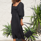 Model holding Black Bare Leather Patsy bag. Front