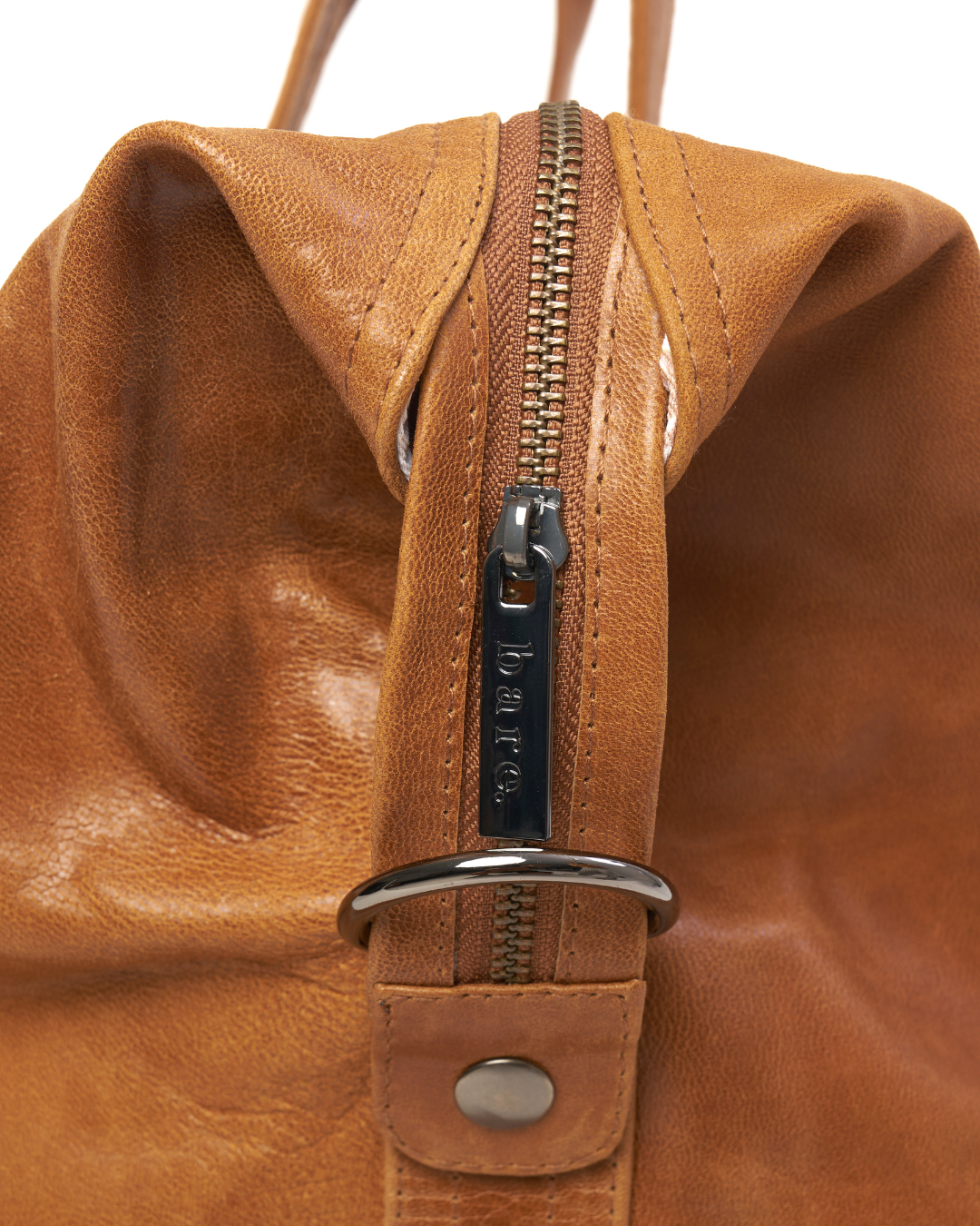 Image is of the zip and hardware on a Camel Bare Leather Travel Bag