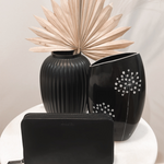 Black Bare Leather Quinn wallet displayed on a table. Front