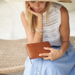 Model holding a Camel Bare Leather Quinn Wallet