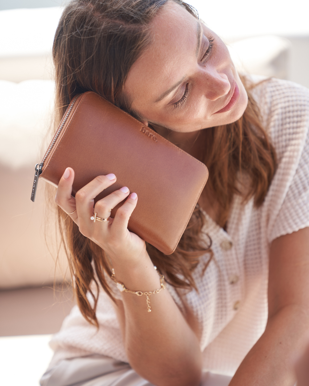 Model holding a Camel Bare Leather Quinn Wallet