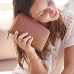 Model holding a Camel Bare Leather Quinn Wallet