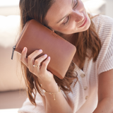 Model holding a Camel Bare Leather Quinn Wallet