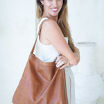 Model holding the Camel Bare Leather Lulu bag over her shoulder