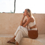 Model posing with Bare Leather Harper bag in Camel
